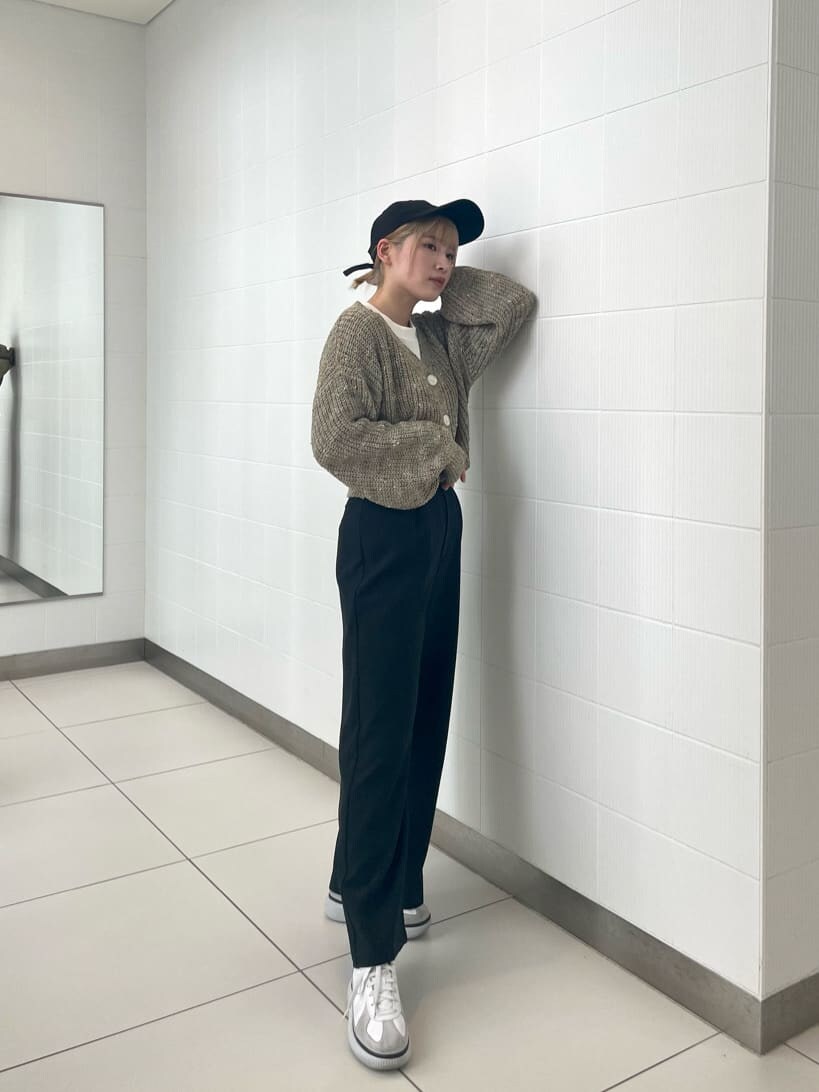 ブラック系のスラックス、ベージュ系のカーディガン/ボレロを着用したレディースの冬コーディネートの2枚目の写真