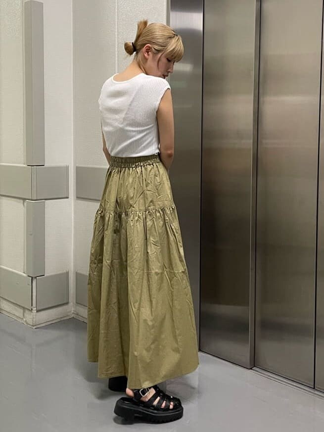 ブラック系のハンドバッグ、ブラック系のサンダル、ホワイト系のタンクトップを着用したレディースの夏コーディネートの4枚目の写真