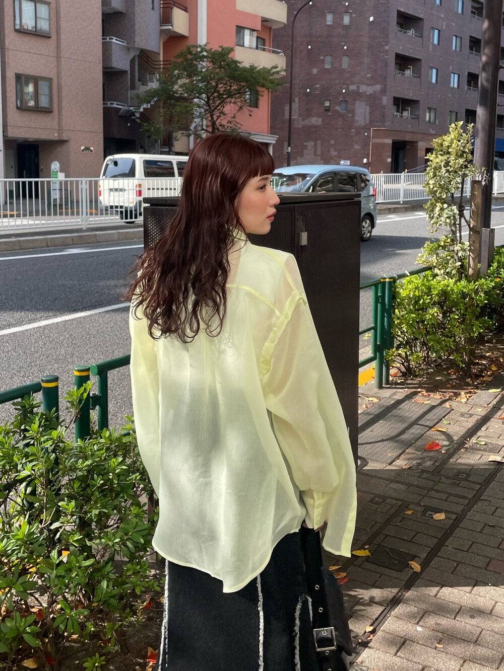 イエロー系のシャツ/ブラウス、ブラック系のデニムスカートを着用したレディースの冬コーディネートの4枚目の写真