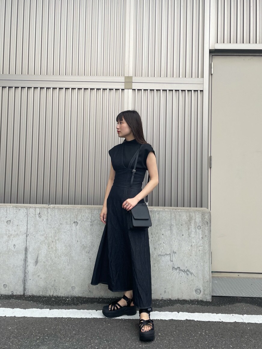 ブラック系のワンピース、ブラック系のサンダル、ブラック系のハンドバッグを着用したレディースの春コーディネートの2枚目の写真