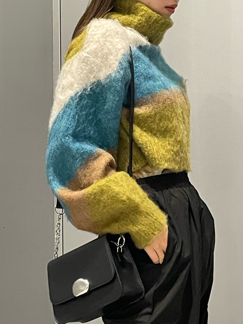 その他のニット/セーター、ブラック系のブーツ、ブラック系のショルダーバッグを着用したレディースの秋コーディネートの5枚目の写真