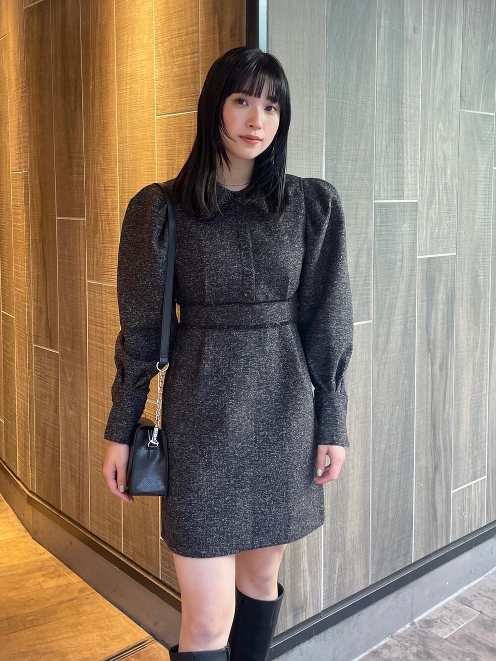 ブラック系のワンピース、ブラック系のブーツ、ブラック系のショルダーバッグを着用したレディースの冬コーディネートの4枚目の写真