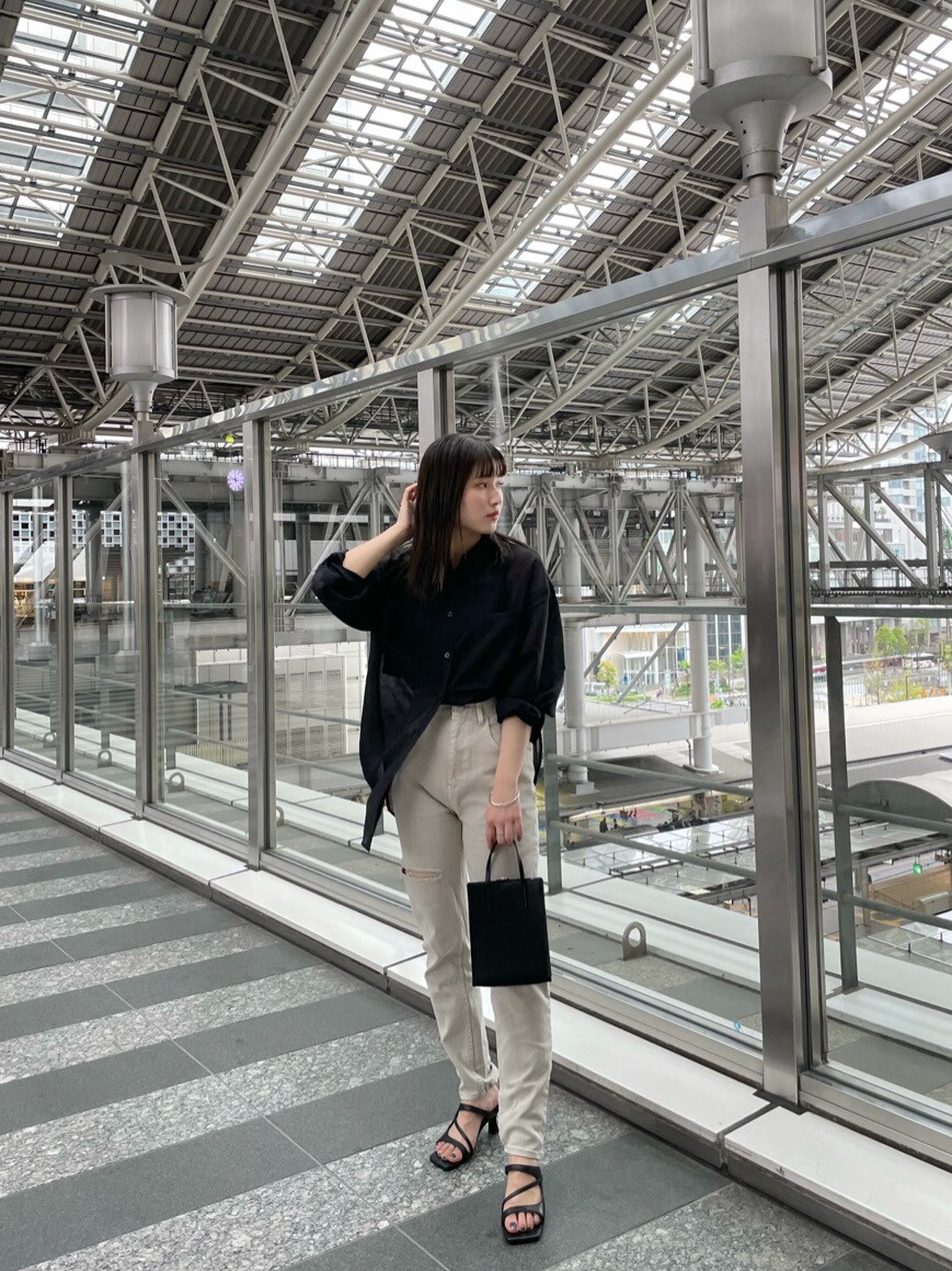 ブラック系のショルダーバッグ、ブラック系のシャツ/ブラウス、グレー系のその他パンツを着用したレディースの春コーディネートの4枚目の写真