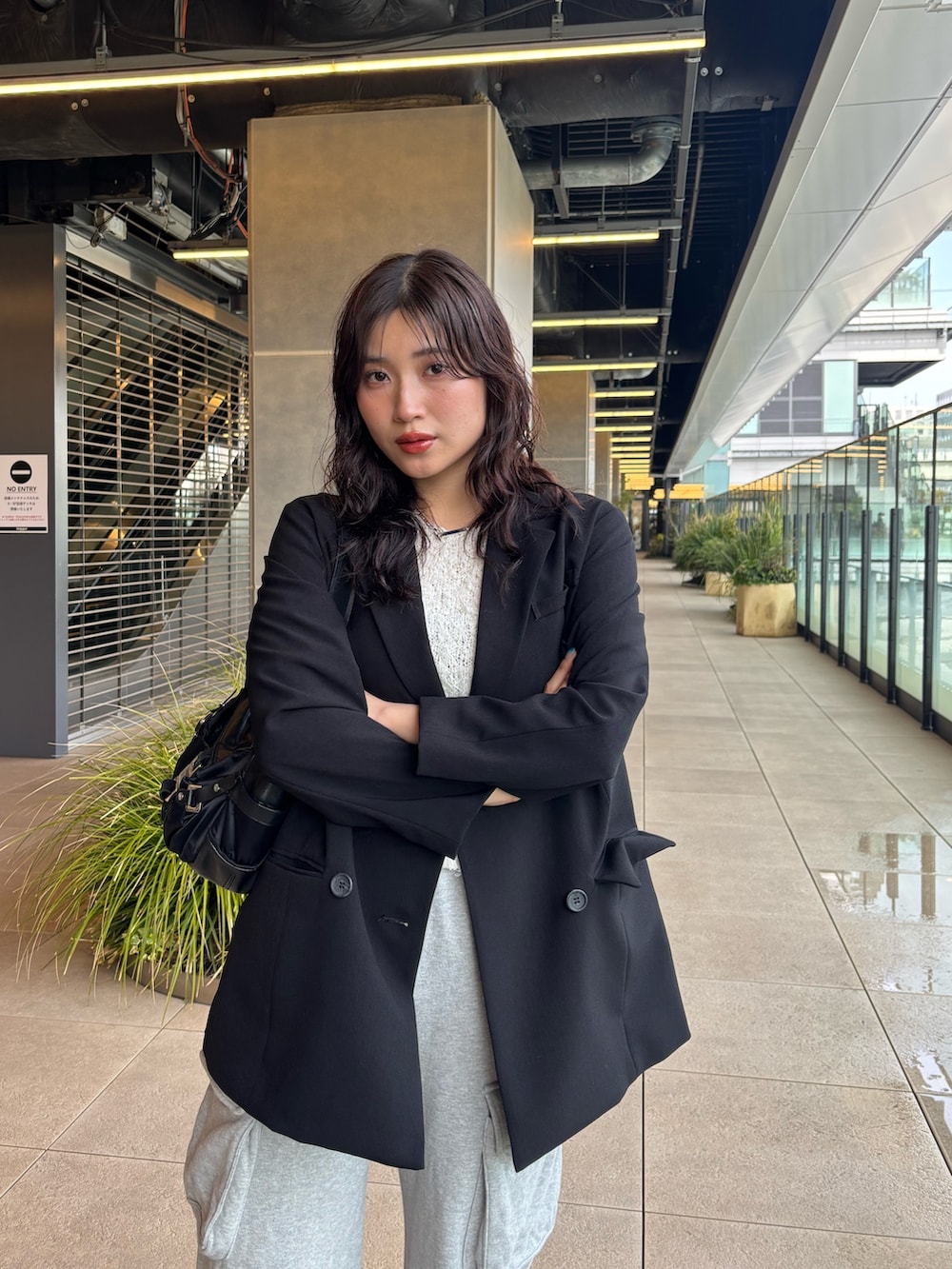 ブラック系のテーラードジャケット、ホワイト系のニット/セーターを着用したレディースの春コーディネートの3枚目の写真