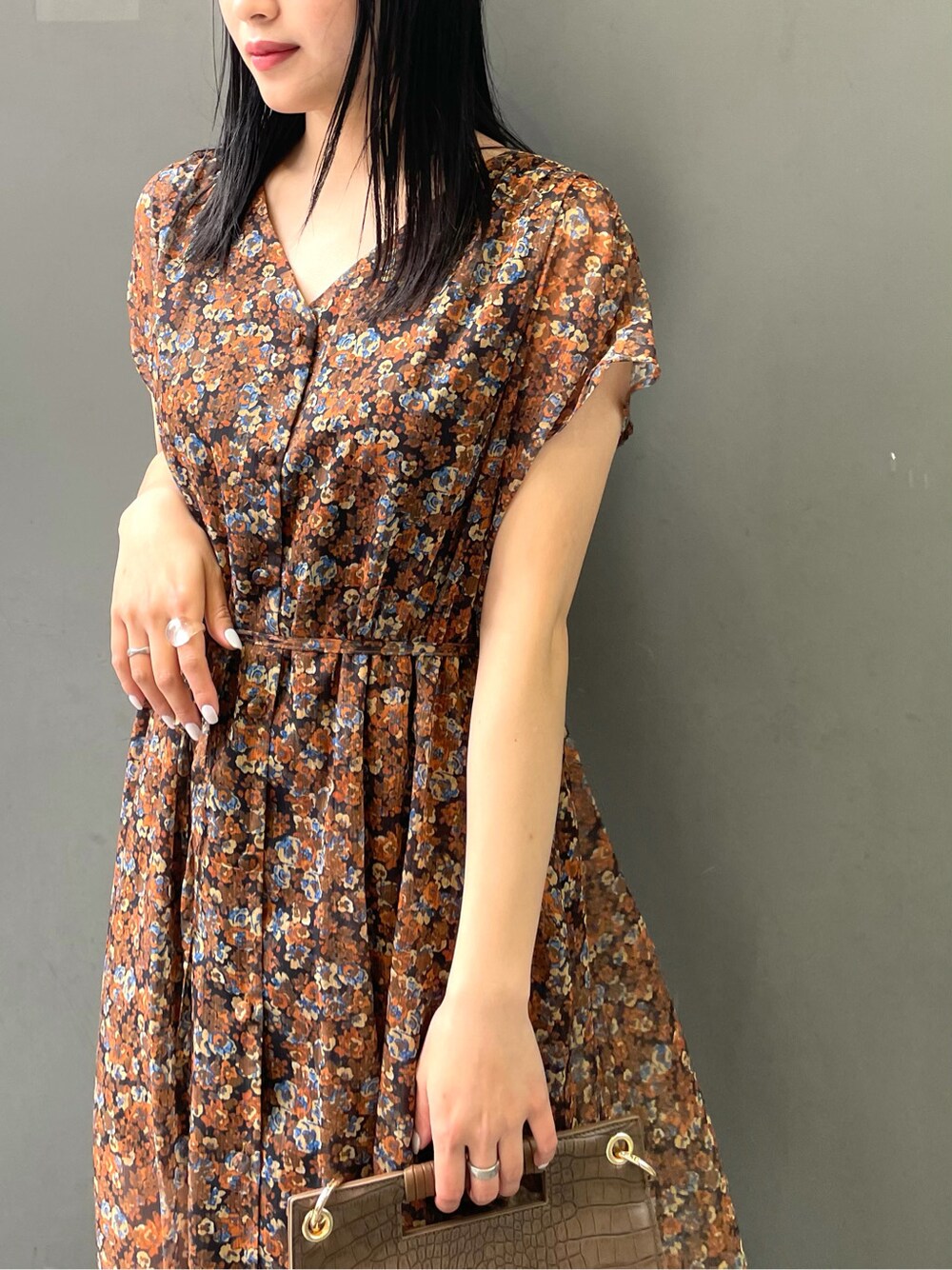 ブラウン系のワンピース、ブラック系のサンダル、ブラウン系のハンドバッグを着用したレディースの春コーディネートの4枚目の写真