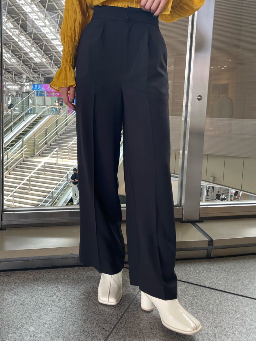 イエロー系のシャツ/ブラウス、ホワイト系のブーツ、ブラック系のスラックスを着用したレディースの夏コーディネートの6枚目の写真