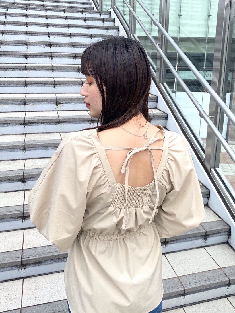 ベージュ系のシャツ/ブラウス、ブルー系のデニムパンツ、ブラック系のハンドバッグを着用したレディースの春コーディネートの5枚目の写真