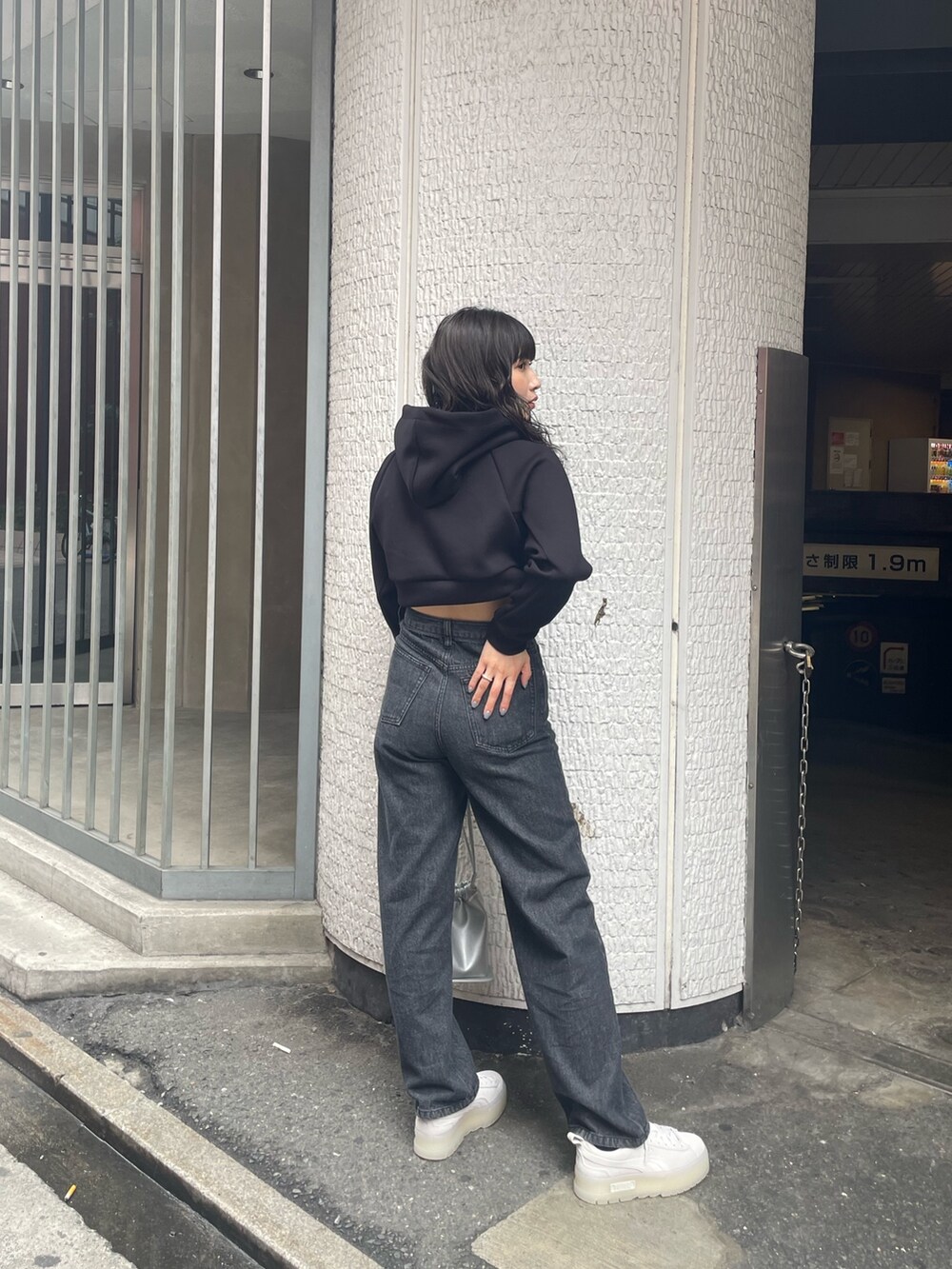 ブラック系のTシャツ/カットソー、ブラック系のデニムパンツ、グレー系のスニーカーを着用したレディースの春コーディネートの3枚目の写真