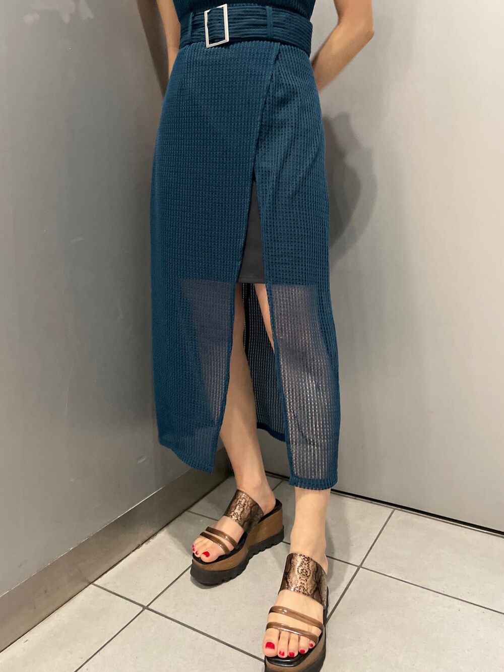 ブルー系のワンピース、ブラック系のTシャツ/カットソー、ブラック系のサンダルを着用したレディースの春コーディネートの3枚目の写真