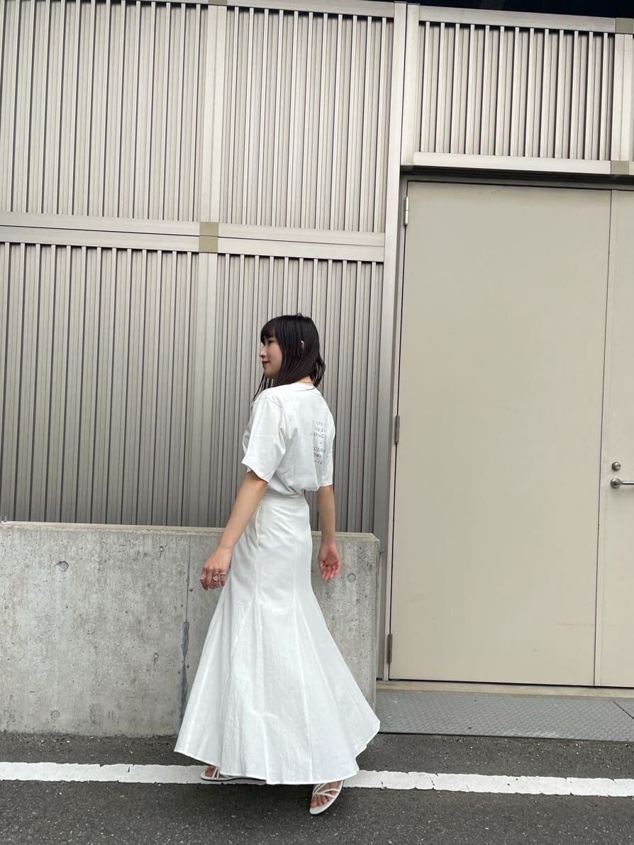 ホワイト系のスカート、ホワイト系のサンダル、ホワイト系のTシャツ/カットソーを着用したレディースの夏コーディネートの3枚目の写真