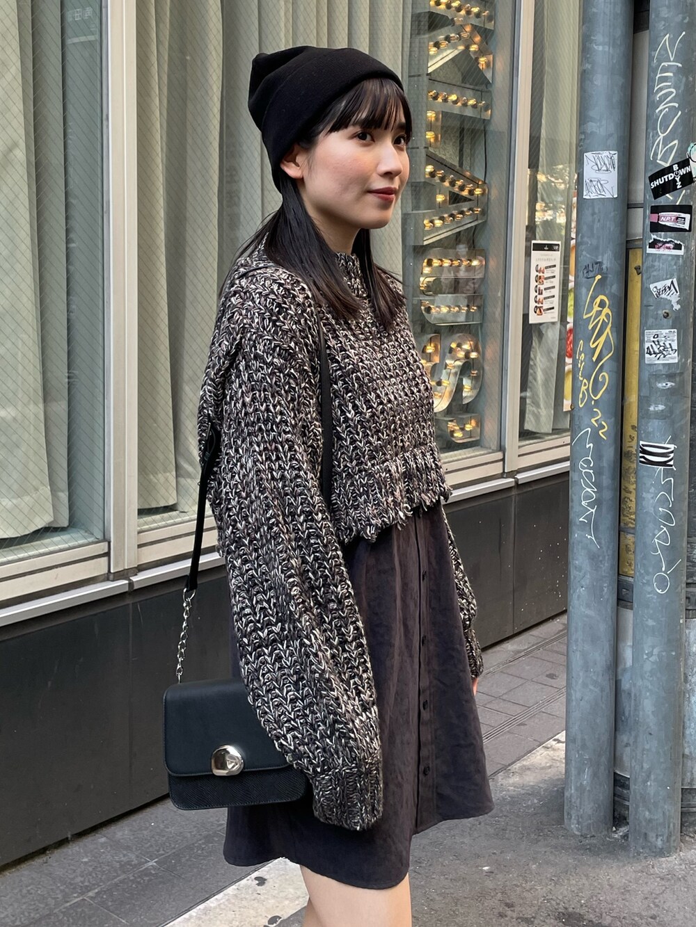 ブラック系のワンピース、ブラック系のブーツ、ブラック系のショルダーバッグを着用したレディースの秋コーディネートの5枚目の写真