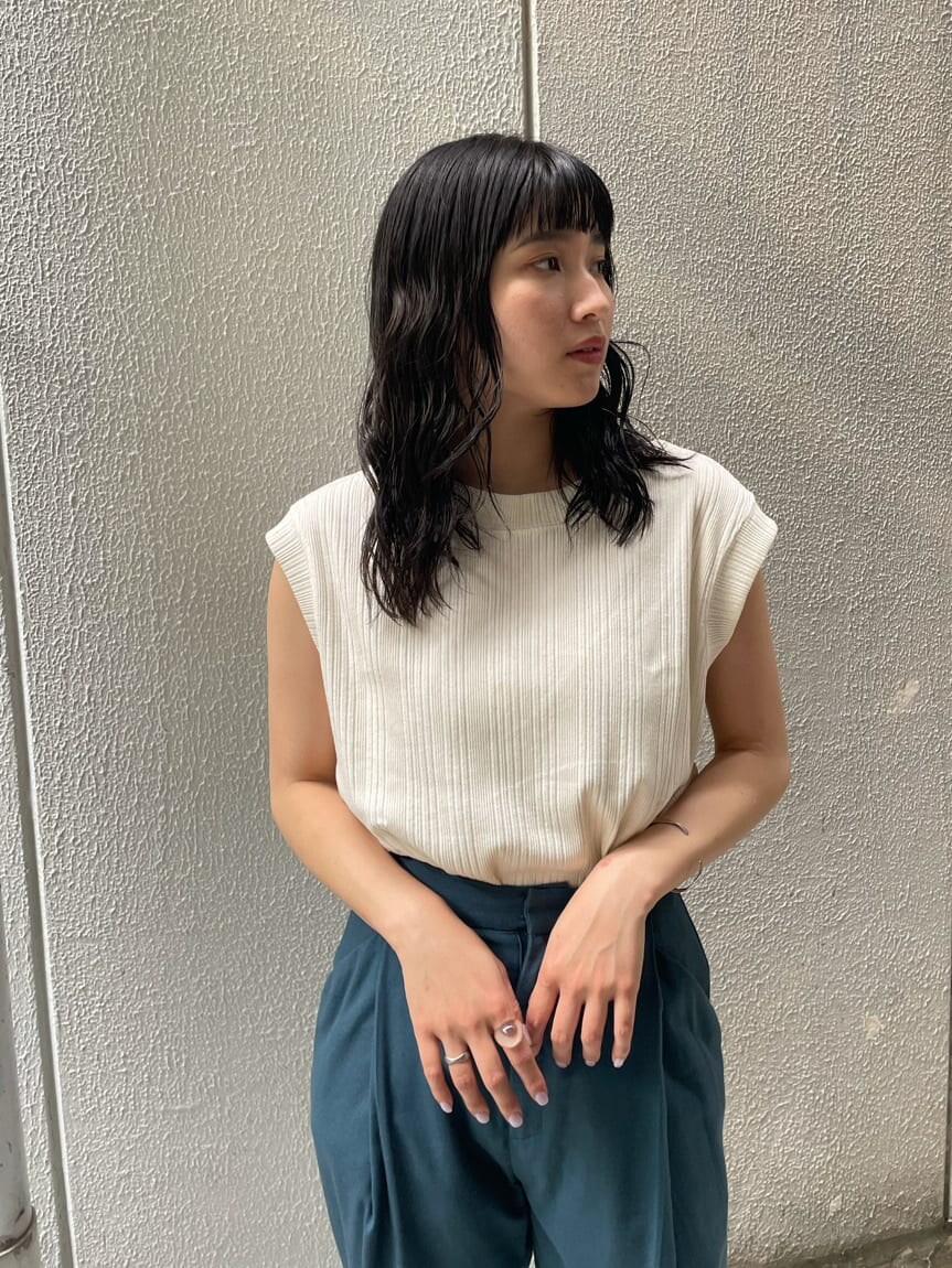 グリーン系のスラックス、ブラック系のサンダル、ホワイト系のTシャツ/カットソーを着用したレディースの夏コーディネートの2枚目の写真