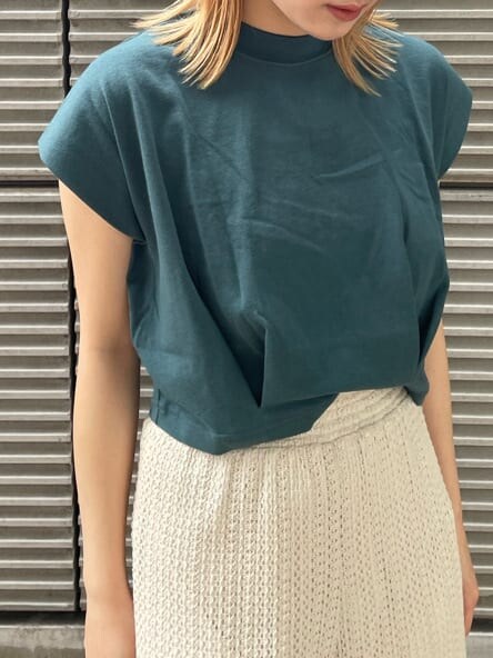 ホワイト系のスウェットパンツ、グリーン系のタンクトップ、ブラック系のサンダルを着用したレディースの春コーディネートの6枚目の写真