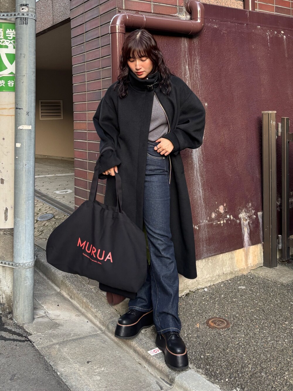 ブラック系のその他アウター、ブラック系のハンドバッグを着用したレディースの冬コーディネートの2枚目の写真