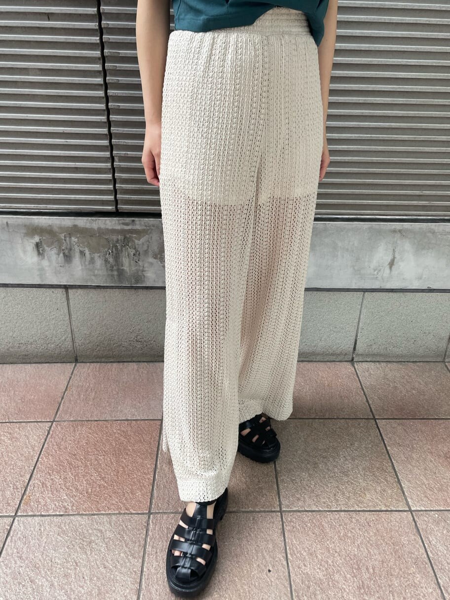 ホワイト系のスウェットパンツ、グリーン系のタンクトップ、ブラック系のサンダルを着用したレディースの春コーディネートの7枚目の写真