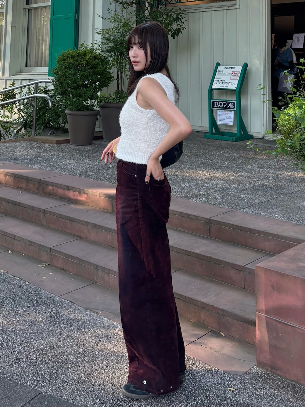 ホワイト系のニット/セーター、レッド系のデニムパンツを着用したレディースの夏コーディネートの2枚目の写真