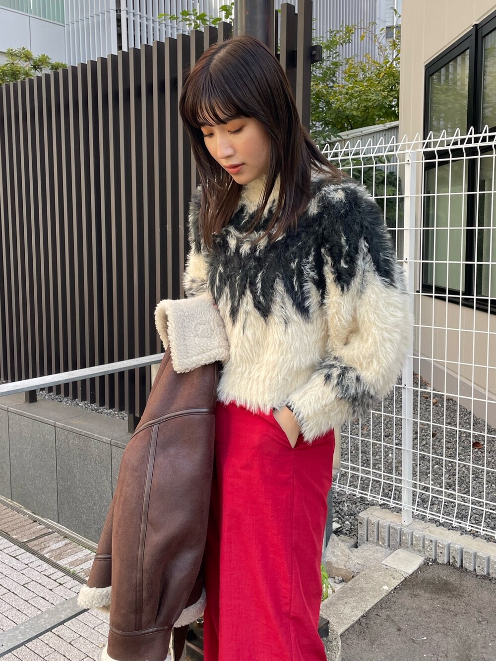 ホワイト系のニット/セーター、ブラウン系のムートンコートを着用したレディースの秋コーディネートの7枚目の写真