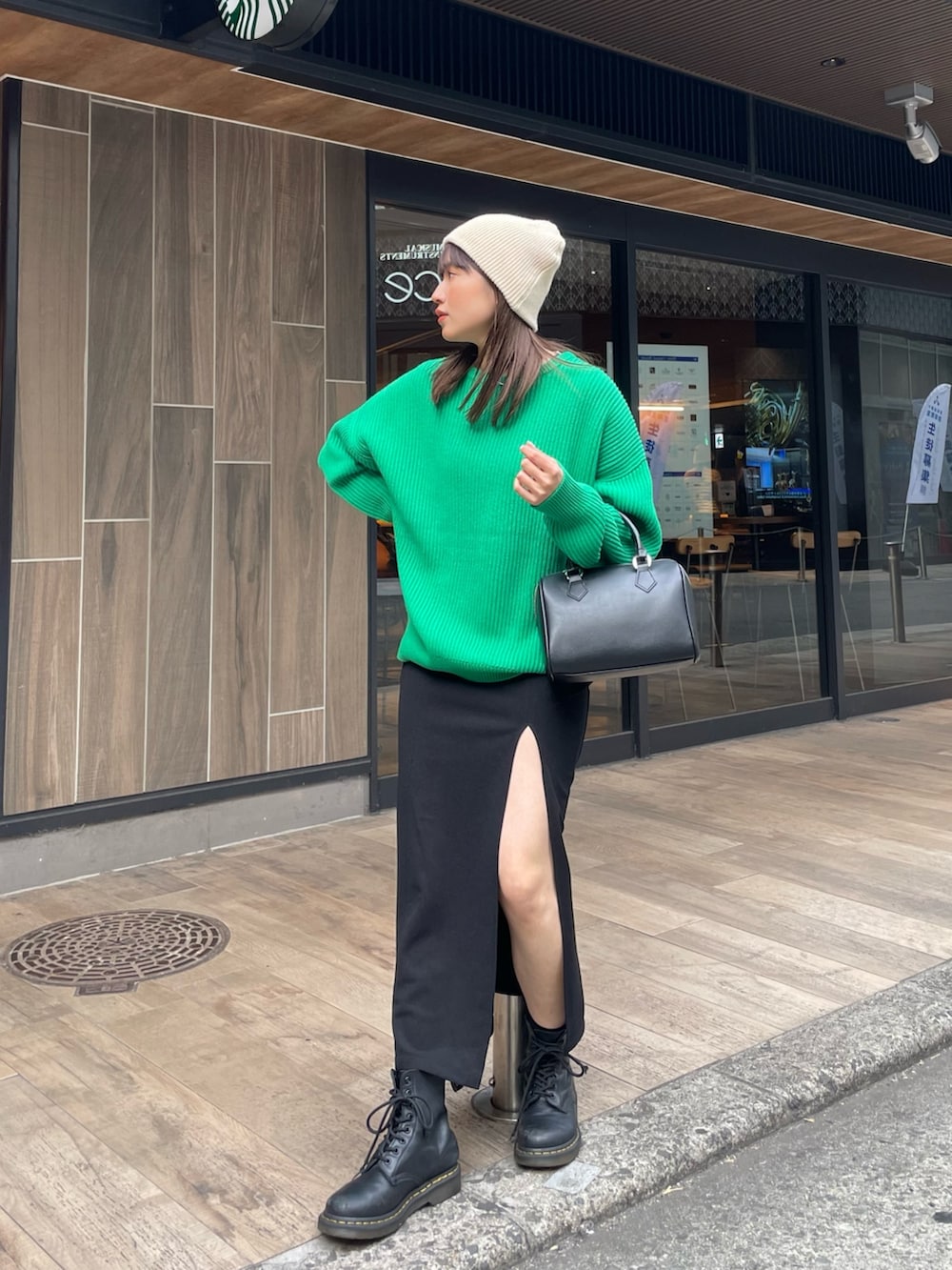 グリーン系のニット/セーター、ブラック系のスカートを着用したレディースの冬コーディネートの4枚目の写真