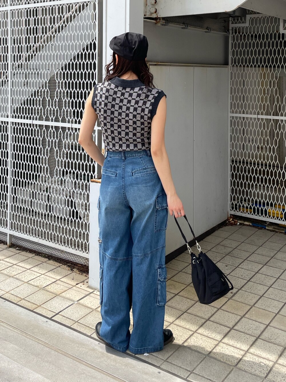 ブルー系のデニムパンツ、ブラック系のニット/セーターを着用したレディースの春コーディネートの2枚目の写真