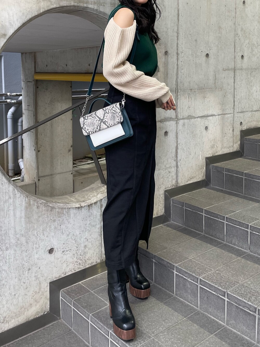 グリーン系のニット/セーター、ブラック系のスカートを着用したレディースの夏コーディネートの3枚目の写真