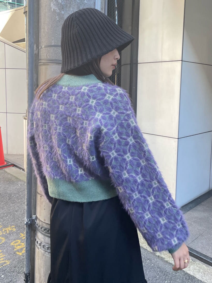 ブラック系のブーツ、ブラック系のスカート、パープル系のニット/セーターを着用したレディースの秋コーディネートの4枚目の写真