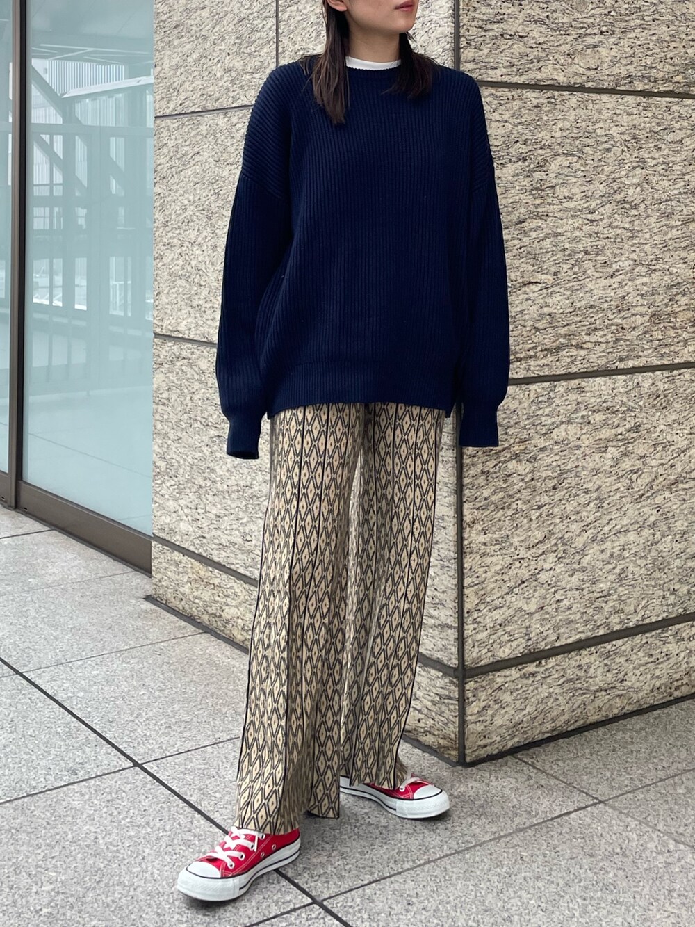 ブルー系のニット/セーター、ブラック系のブルゾンを着用したレディースの秋コーディネートの4枚目の写真