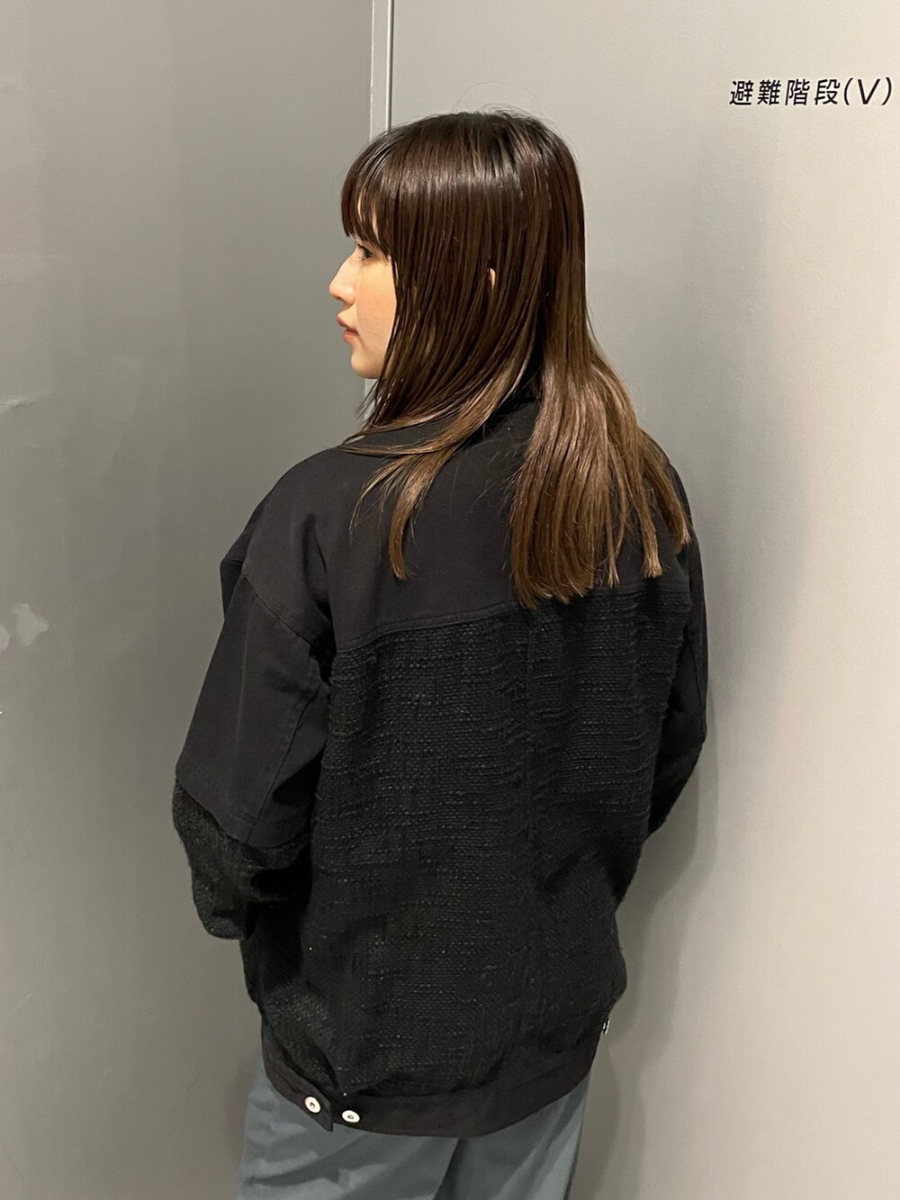 ブラック系のブルゾン、ブルー系のスラックスを着用したレディースの冬コーディネートの6枚目の写真