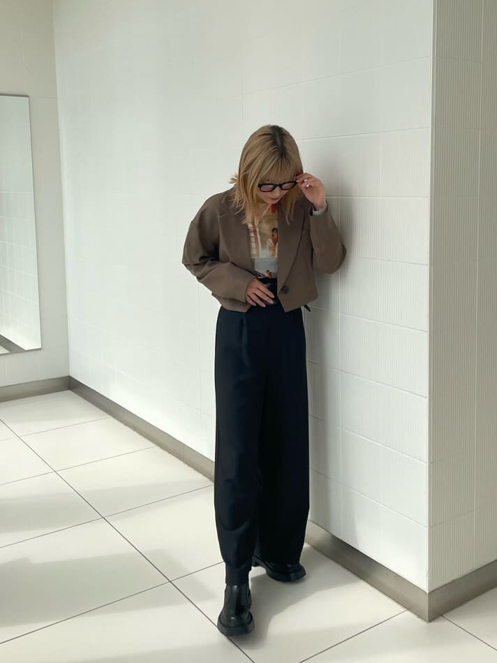 ブラック系のブーツ、ブラック系のスラックス、ブラウン系のテーラードジャケットを着用したレディースの春コーディネートの2枚目の写真