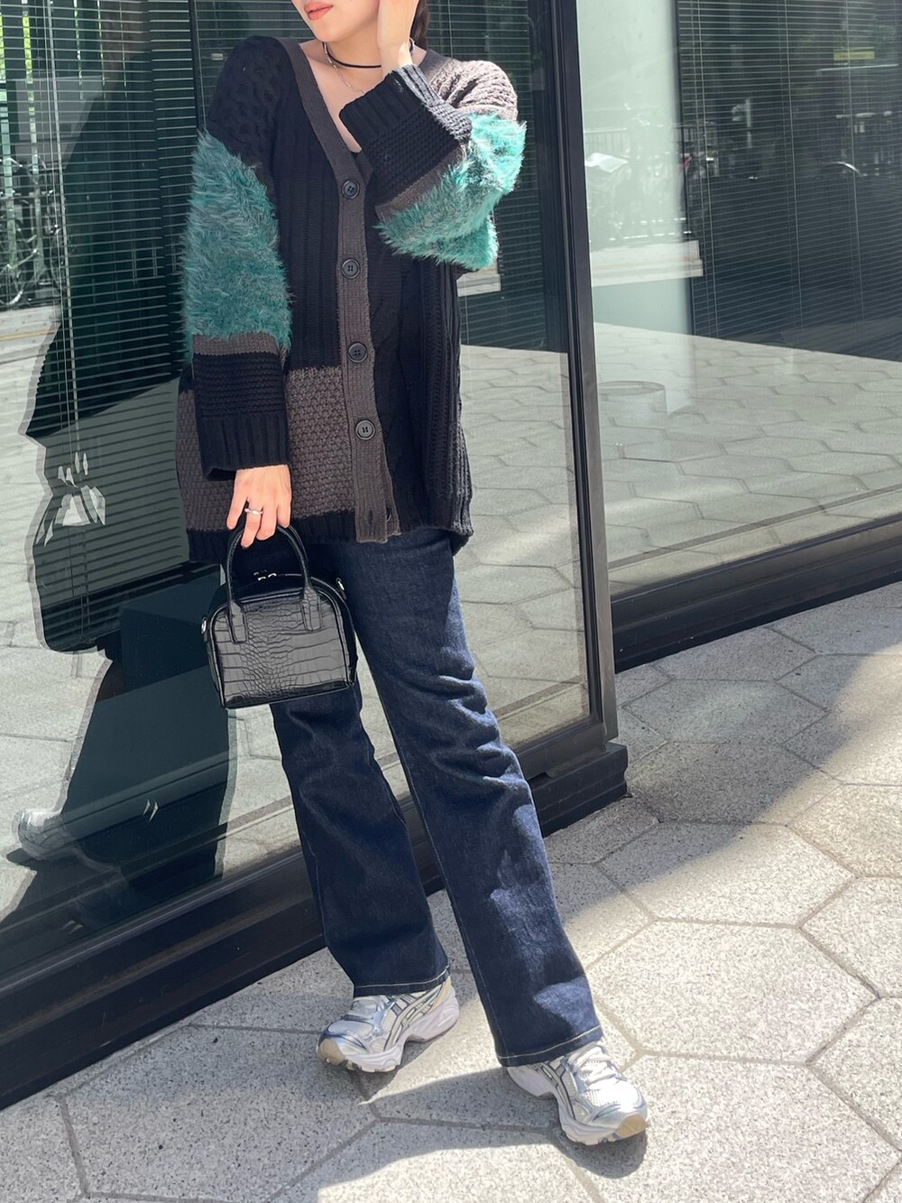 ブラック系のカーディガン/ボレロ、ブルー系のデニムパンツを着用したレディースの秋コーディネートの3枚目の写真