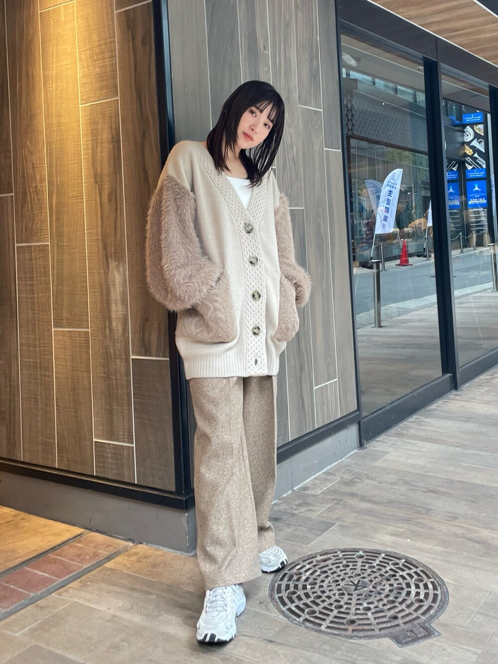 ベージュ系のカーディガン/ボレロ、ブラウン系のスラックスを着用したレディースの冬コーディネートの2枚目の写真