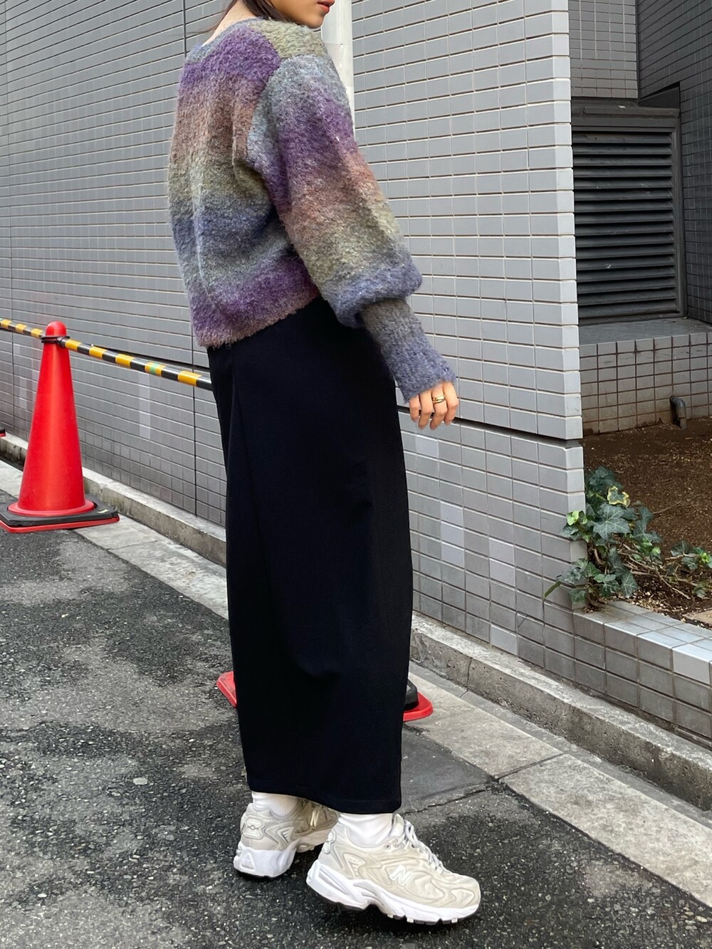 ベージュ系のムートンコート、パープル系のニット/セーター、ブラック系のスカートを着用したレディースの秋コーディネートの6枚目の写真