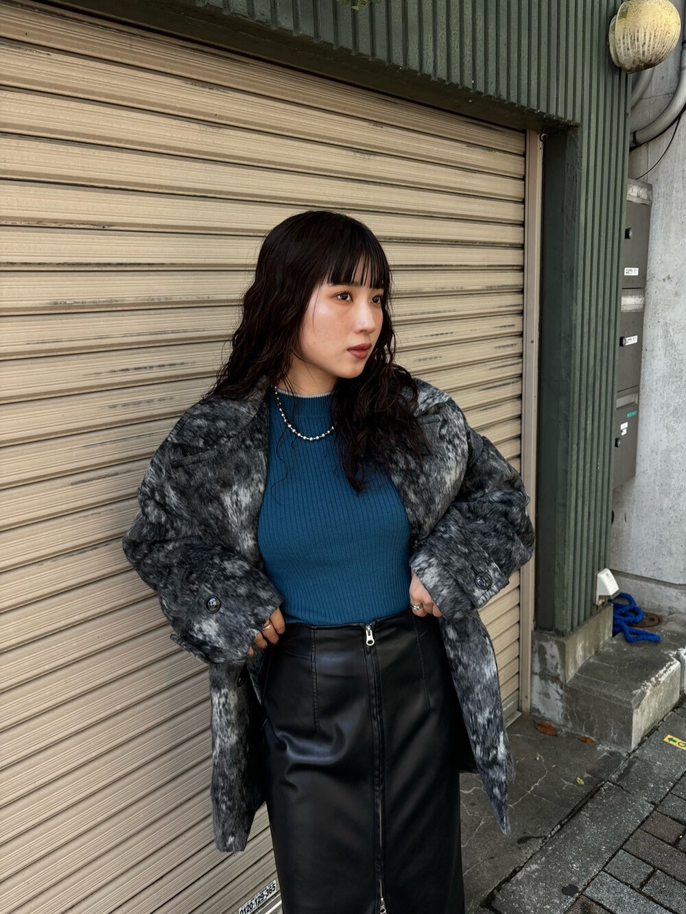 ブルー系のニット/セーター、ブラック系のその他アウター、ブラック系のスカートを着用したレディースの秋コーディネートの4枚目の写真