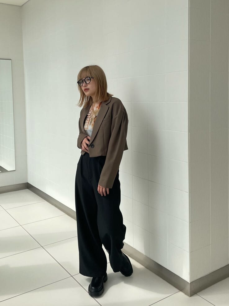 ブラック系のブーツ、ブラック系のスラックス、ブラウン系のテーラードジャケットを着用したレディースの春コーディネートの3枚目の写真