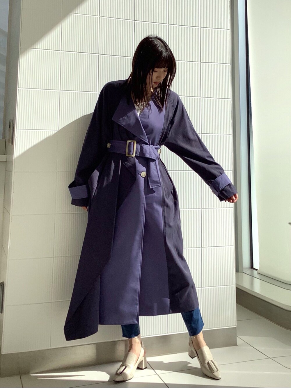 ブルー系のデニムパンツ、ブルー系のトレンチコート、ホワイト系のパンプスを着用したレディースの冬コーディネートの3枚目の写真