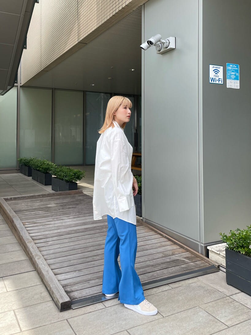 ベージュ系のスニーカー、ホワイト系のシャツ/ブラウス、ブルー系のスラックスを着用したレディースの春コーディネートの3枚目の写真