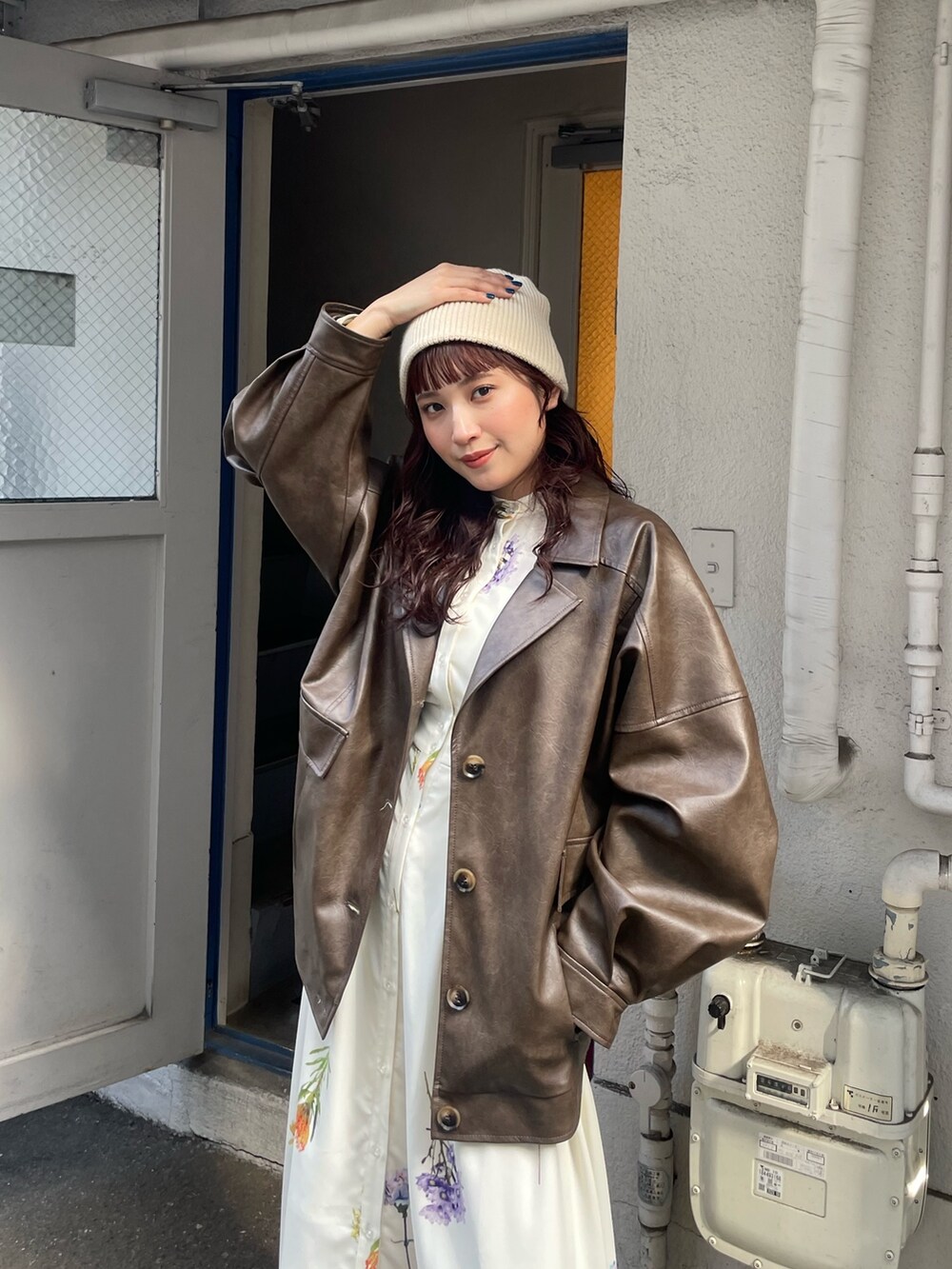 ホワイト系のワンピース、ブラウン系のブルゾンを着用したレディースの冬コーディネートの4枚目の写真