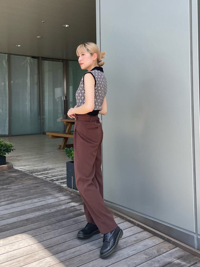 ブラウン系のスラックス、ブラック系のニット/セーターを着用したレディースの夏コーディネートの2枚目の写真
