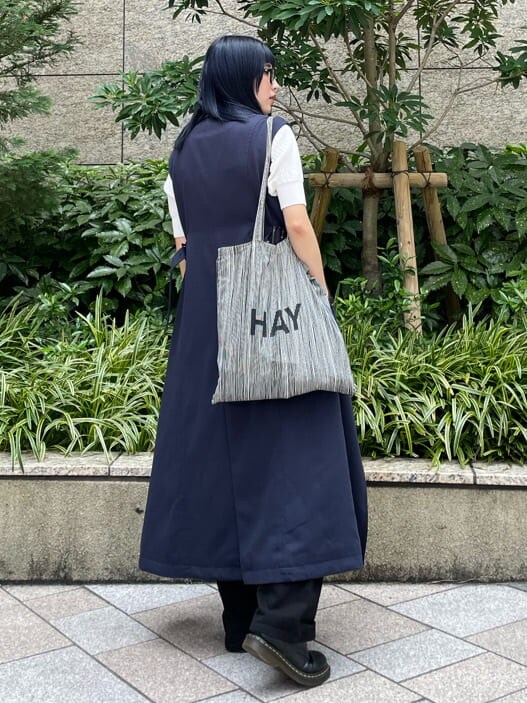 ブラック系のデニムパンツ、ブルー系のトレンチコートを着用したレディースの夏コーディネートの4枚目の写真