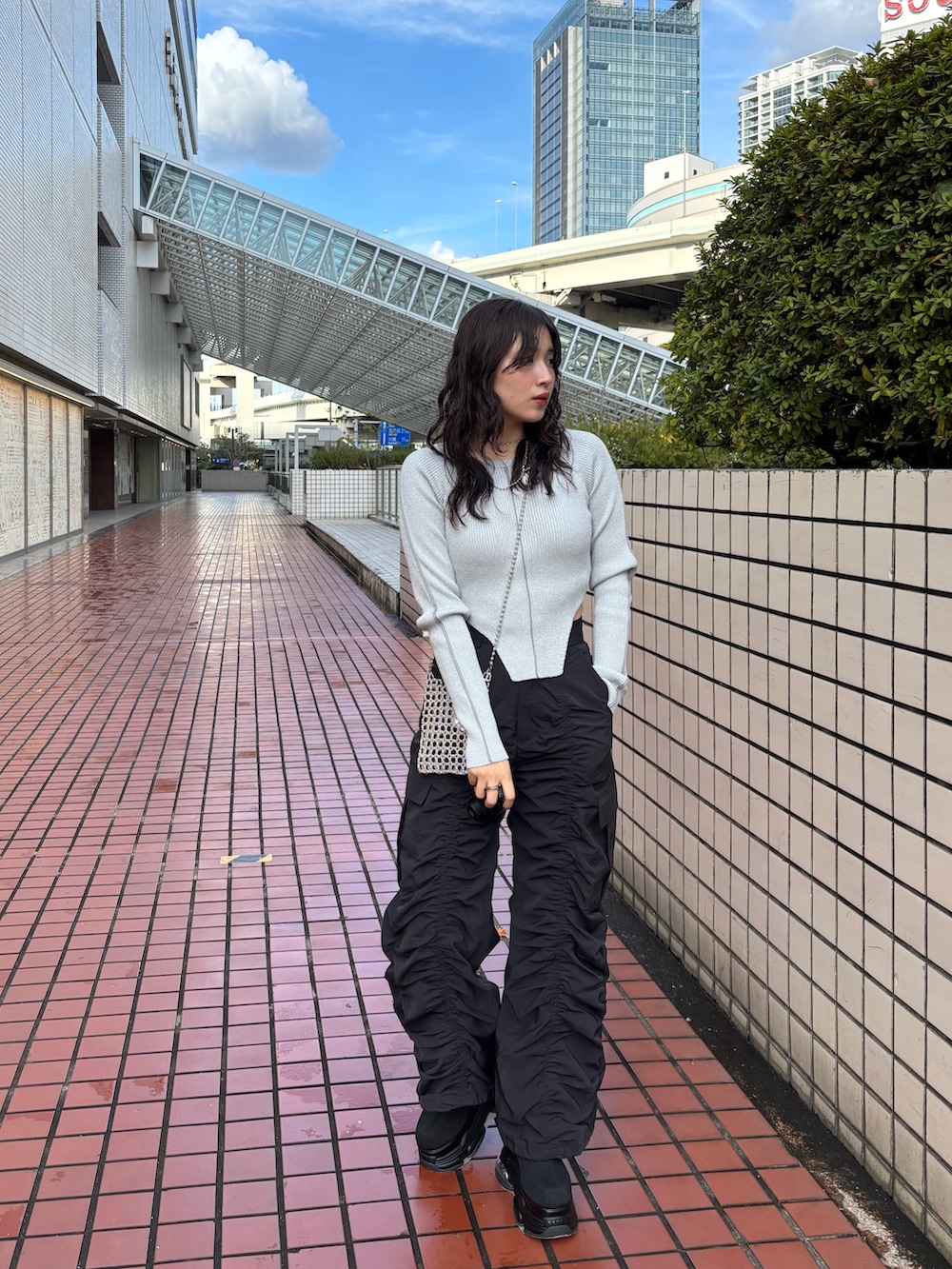 シルバー系のショルダーバッグ、ブラック系のデニムパンツ、グレー系のニット/セーターを着用したレディースの春コーディネートの2枚目の写真