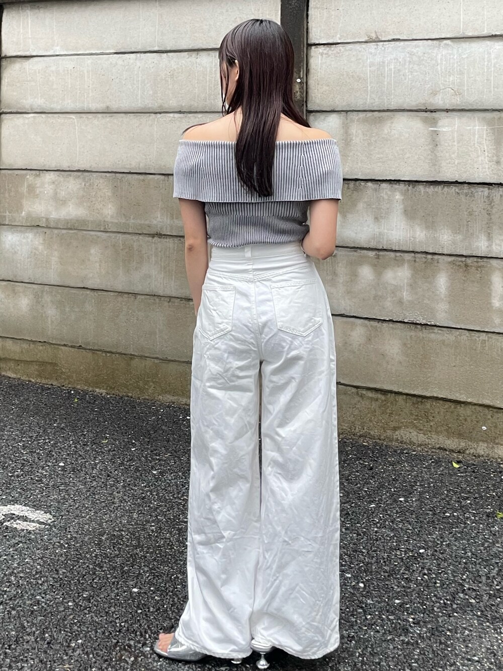 ホワイト系のニット/セーター、ホワイト系のデニムパンツを着用したレディースの春コーディネートの2枚目の写真