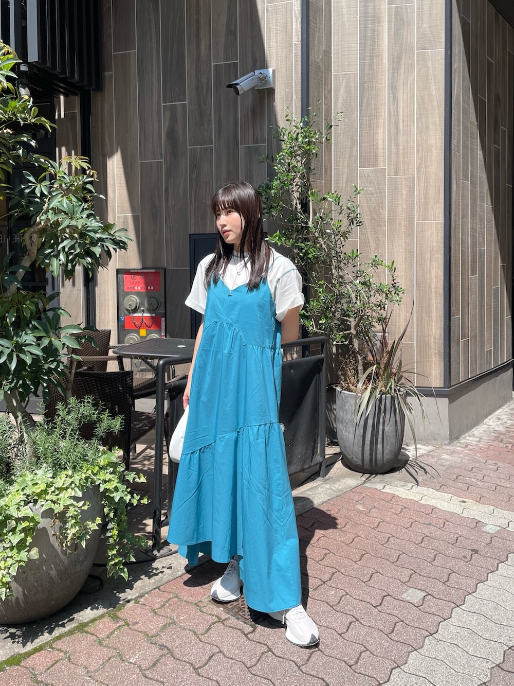 ブルー系のワンピース、ホワイト系のTシャツ/カットソー、シルバー系のネックレスを着用したレディースの春コーディネートの2枚目の写真