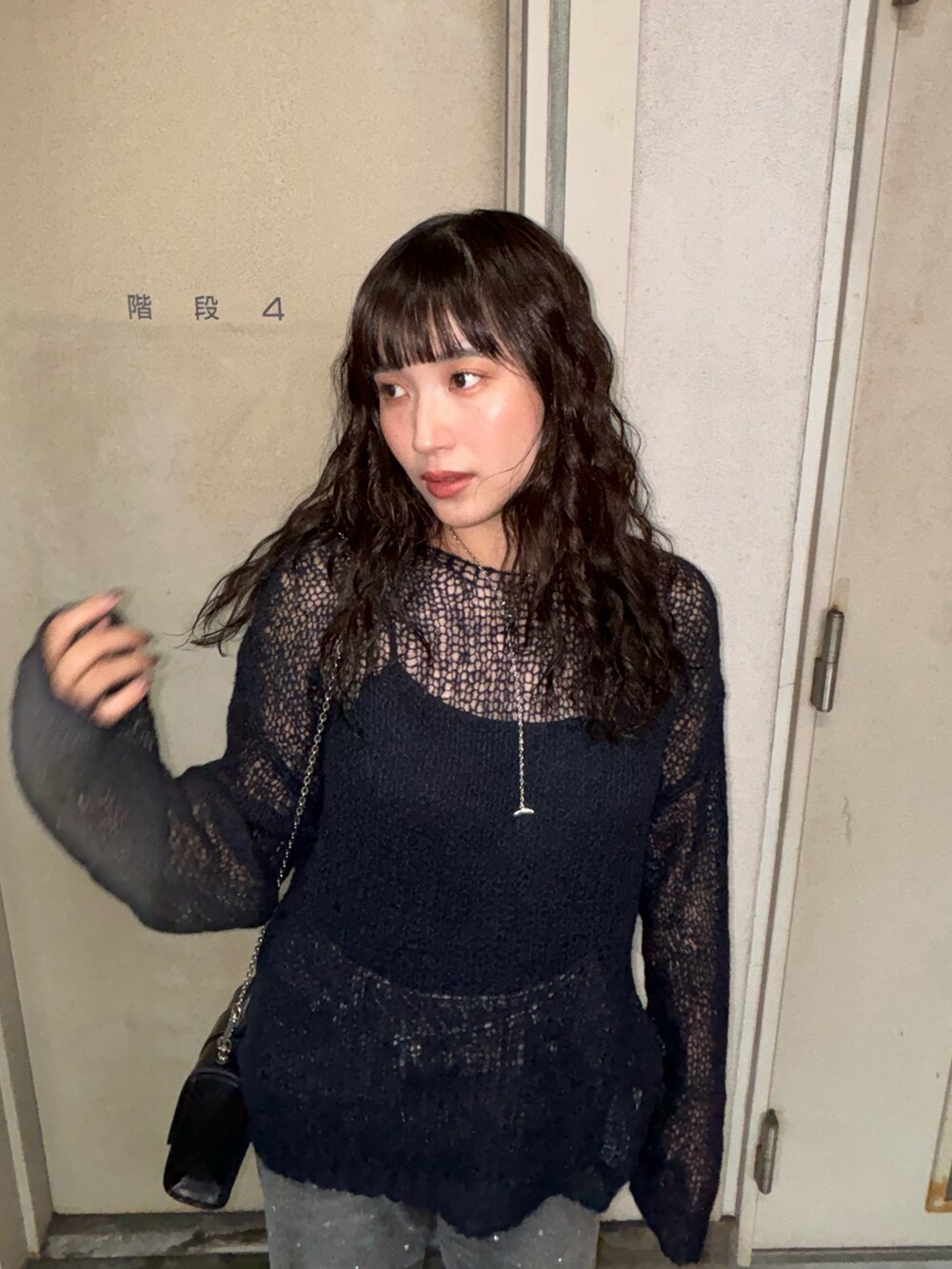 ブラック系のデニムパンツを着用したレディースの秋コーディネートの4枚目の写真