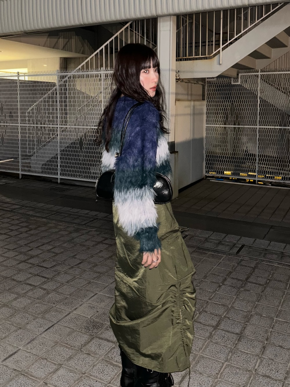 ブルー系のニット/セーター、グリーン系のスカート、ブラック系のブーツを着用したレディースの秋コーディネートの2枚目の写真