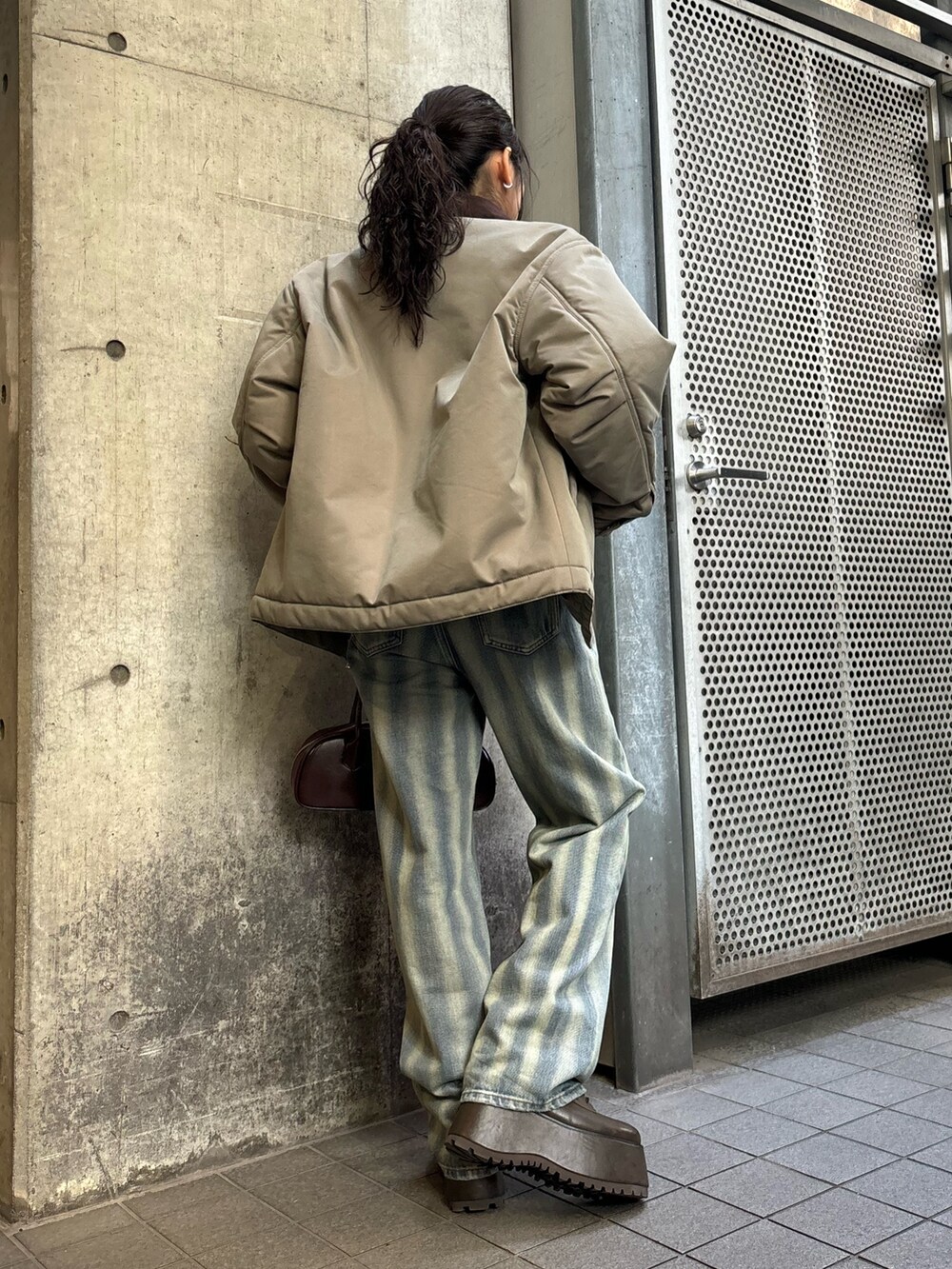 ベージュ系のブルゾン、ブルー系のデニムパンツを着用したレディースの秋コーディネートの3枚目の写真