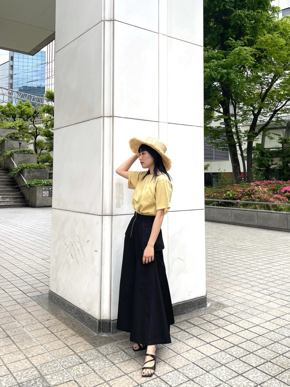 ブラック系のスカート、ブラック系のサンダル、イエロー系のTシャツ/カットソーを着用したレディースの春コーディネートの2枚目の写真