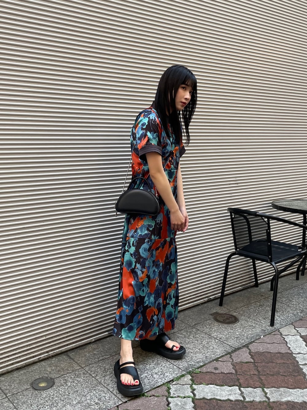 ブルー系のワンピース、ブラック系のサンダルを着用したレディースの春コーディネートの2枚目の写真