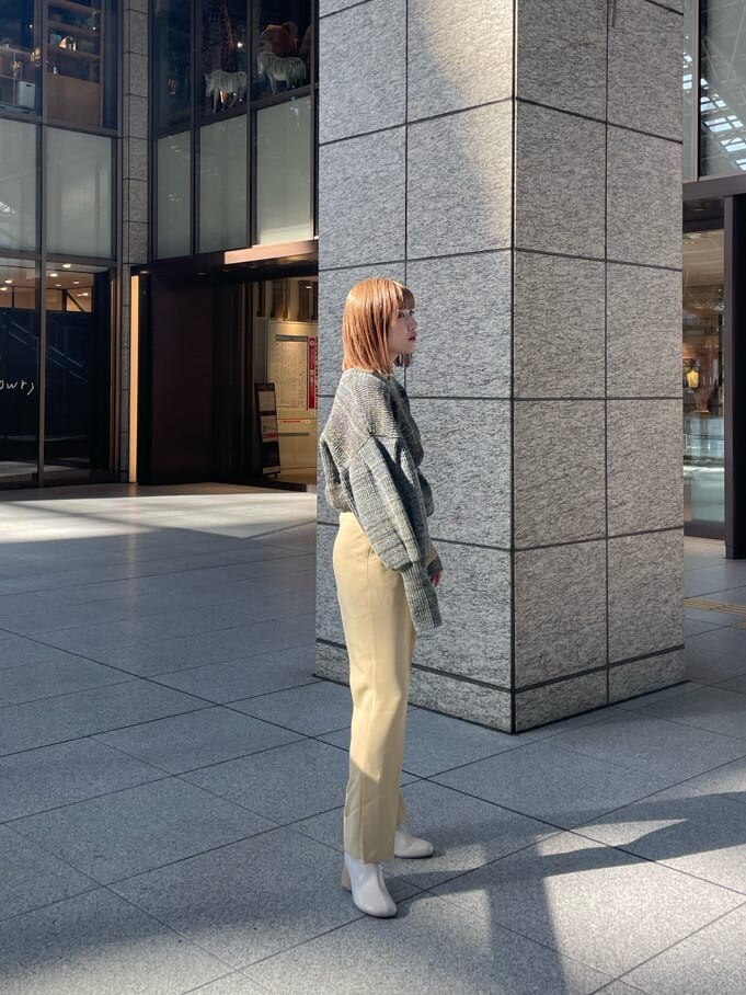 ホワイト系のブーツ、イエロー系のスラックス、ブラウン系のニット/セーターを着用したレディースの冬コーディネートの2枚目の写真