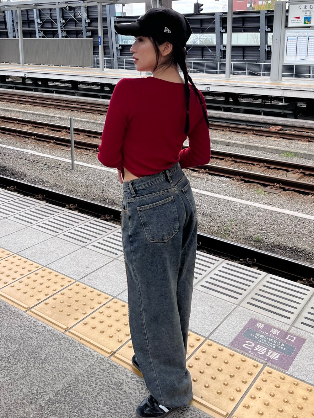 レッド系のTシャツ/カットソーを着用したレディースの冬コーディネートの2枚目の写真