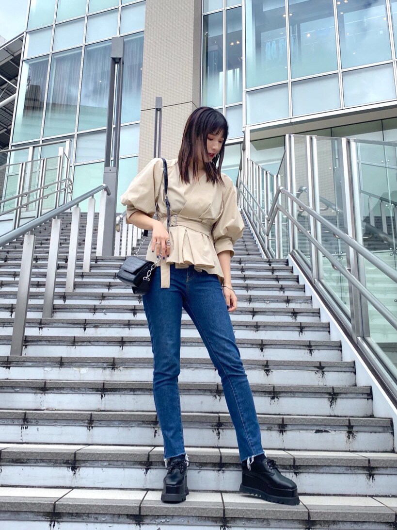 ベージュ系のシャツ/ブラウス、ブルー系のデニムパンツ、ブラック系のハンドバッグを着用したレディースの春コーディネートの2枚目の写真