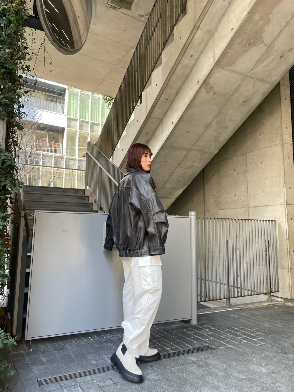 グレー系のブルゾン、ブルー系のニット/セーター、ホワイト系のカーゴパンツを着用したレディースの冬コーディネートの3枚目の写真